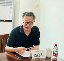 穿黑色衣服的人在桌子前摆拍 中度可信度描述已自动生成